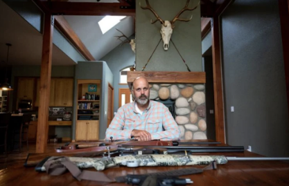 Ryan Busse Portrait with Guns lined out on his table